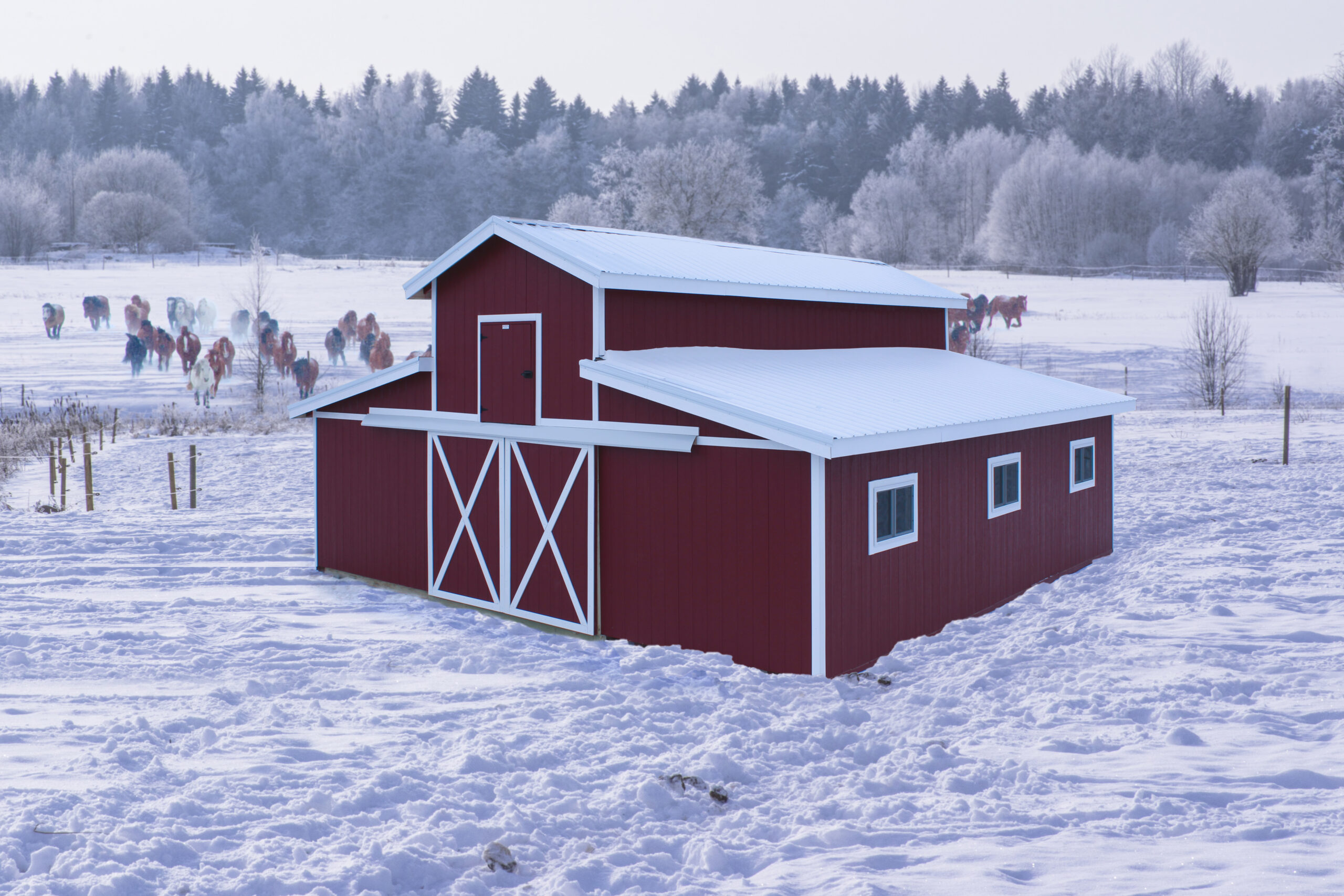 Large 2-story horse barn with red siding and white trim in snow.