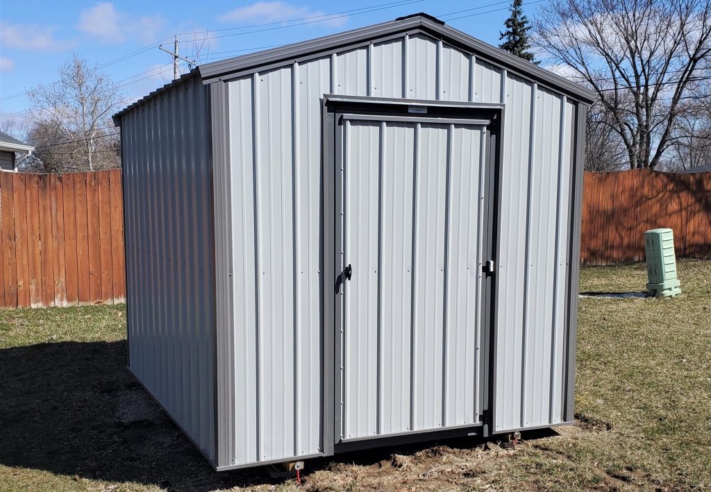 8x10 metal shed with light gray siding and dark gray trim in a backyard.