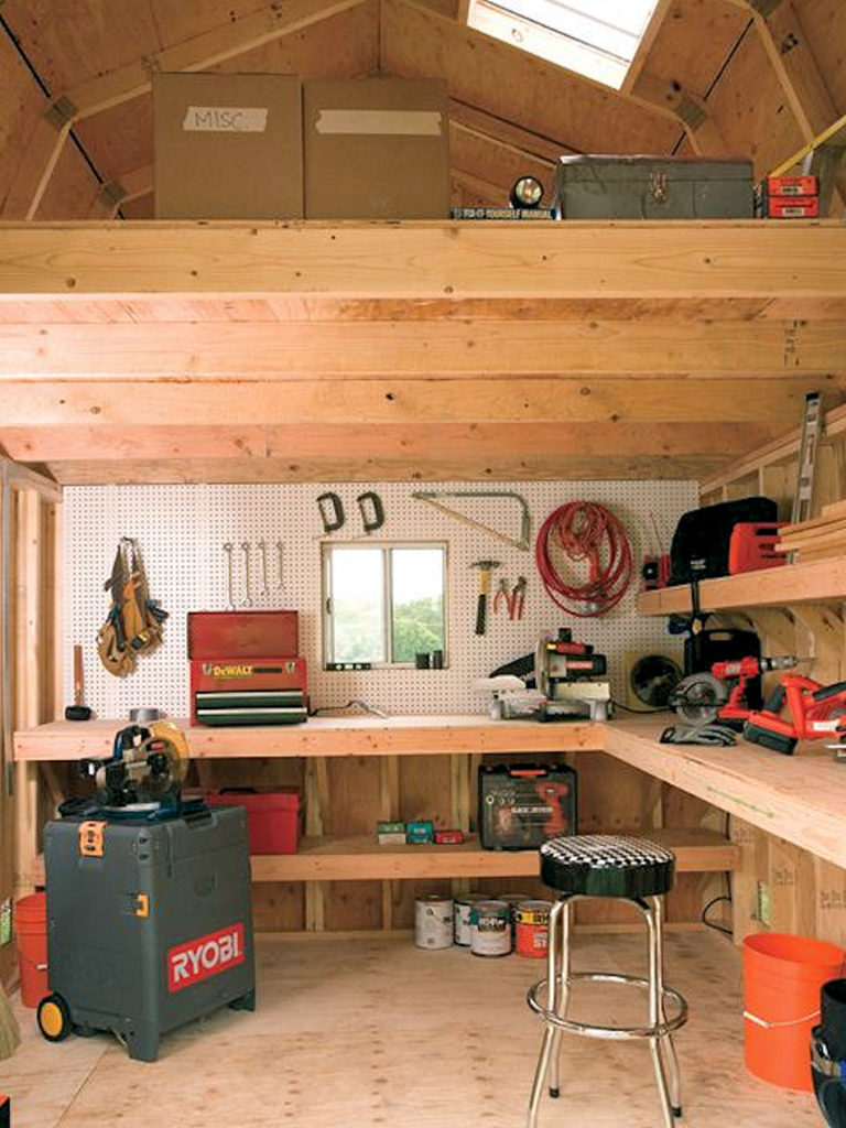 Interior of a shed with organized tools, equipment, a loft, a workbench, and a pegboard.