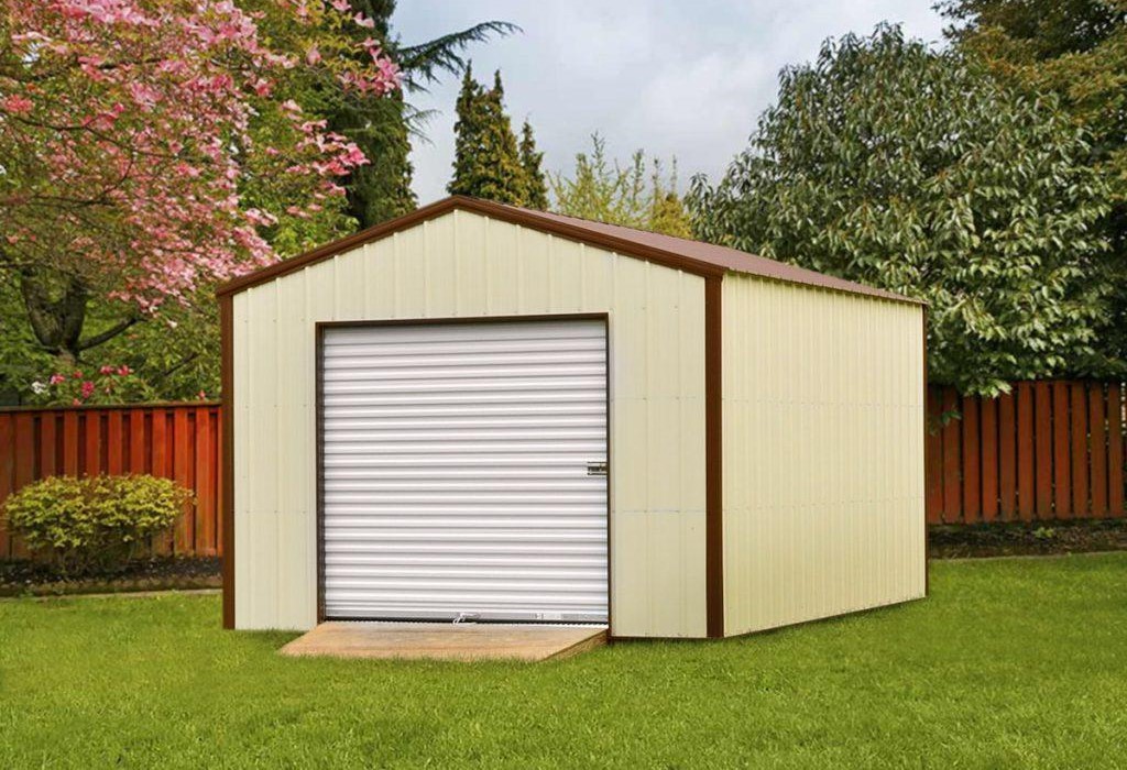 Storage building with beige siding, brown trim, a brown metal roof, and a white roll-up garage door with a ramp sitting in a fenced-in backyard.